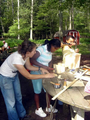Emily, our woodworking instructor, helps Troi with her project
